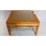 A Chinese style teak low table with inset rattan top and drop in glass section. 50x88x88cm