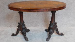 A 19th century burr walnut oval topped centre table on twin carved pedestal supports. H.73 W.112 D.