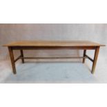 A large 19th century plank top refectory dining table on square stretchered supports fitted slide