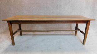 A large 19th century plank top refectory dining table on square stretchered supports fitted slide