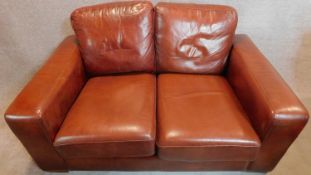 A Thomas Lloyd two seater leather sofa in tan leather. 87x155x97cm