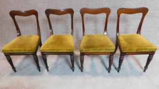 A set of four mid Victorian mahogany dining chairs with shaped backs, mustard upholstery on turned