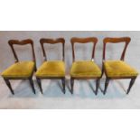 A set of four mid Victorian mahogany dining chairs with shaped backs, mustard upholstery on turned