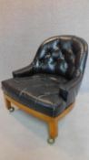 A low club tub chair in black buttoned faux leather. H.75cm (one button missing)