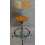 A vintage revolving adjustable industrial machinist's stool with laminated beech seat and back.