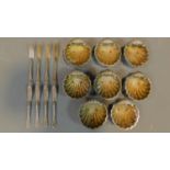 A set of eight scallop design silver plated salts with knives.