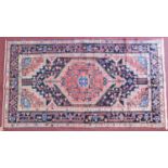 A Persian Toserkan rug, central double pendant medallion with repeating petal motifs on a rouge