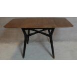 A vintage 1970's teak drop flap dining table on ebonised splay supports. 75x138x81cm