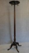 A mahogany coatstand with triple brass hooks on reeded column on quadruped carved cabriole