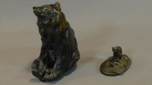 A figure of a seated bear and a small bronze figure of the cat sitting on the mat. H.25 (tallest)