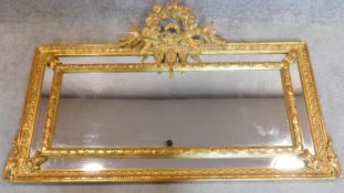 A decorative giltwood wall mirror with carved garland and ribbon cresting. 130x80cm