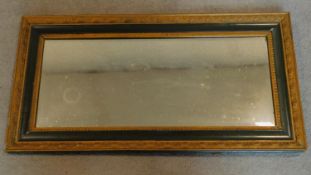 A 19th century gilt and green painted wall mirror. 84x44cm