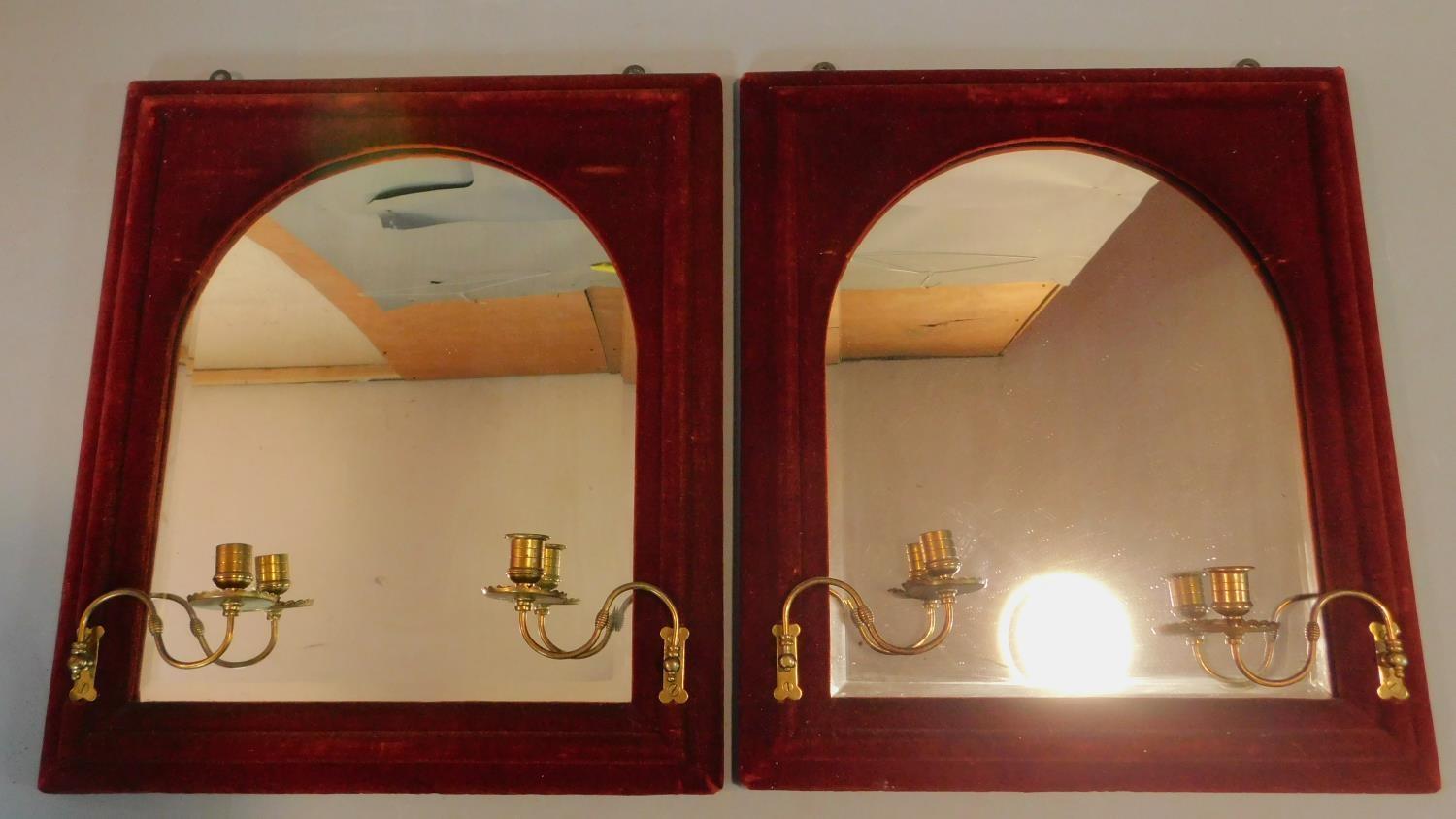 An unusual pair of arched Victorian pier mirrors in red velvet frames fitted with candle sconces.