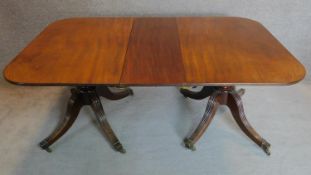 A Georgian Cuban mahogany twin pillar dining table on reeded quadruped outswept supports terminating