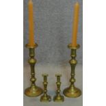 A large pair of 19th century turned brass candlesticks and a similar smaller pair. H.49cm