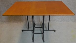 A vintage teak folding table with gateleg action on metal base. 73x123x78cm