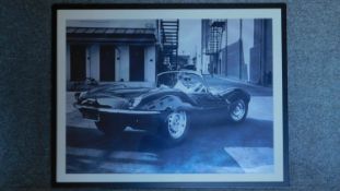 A large framed and glazed photographic reproduction, Steve McQueen in a car on the back lot of a