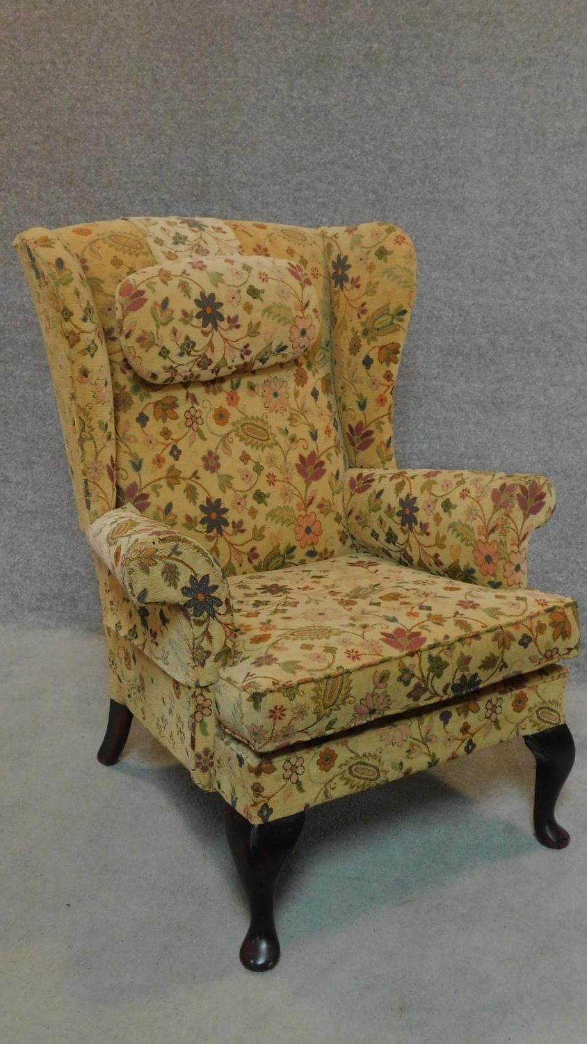 A Georgian style Parker Knoll wingback armchair in floral tapestry upholstery. H.96cm