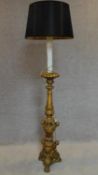 A carved giltwood floor standing standard lamp with carved cherub decoration on tripod carved paw