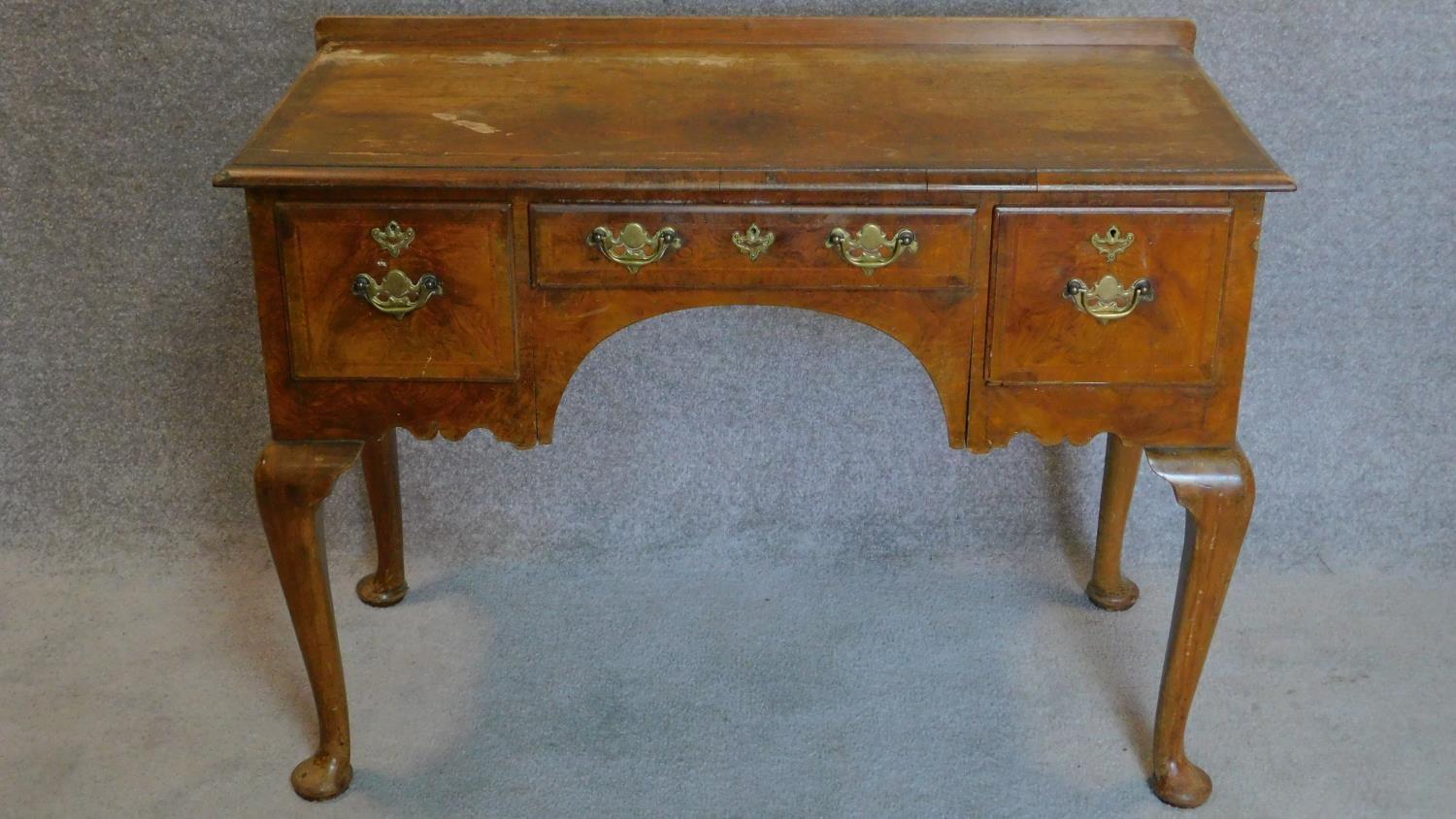 A mid Georgian style walnut and featherbanded lowboy on cabriole supports. 77x106x51cm