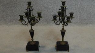 A pair of late 19th century brass five sconce candelabra on slate bases raised on brass paw feet.