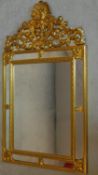 A carved giltwood wall mirror with mirrored panels and scrolling foliate cresting. 109x62cm
