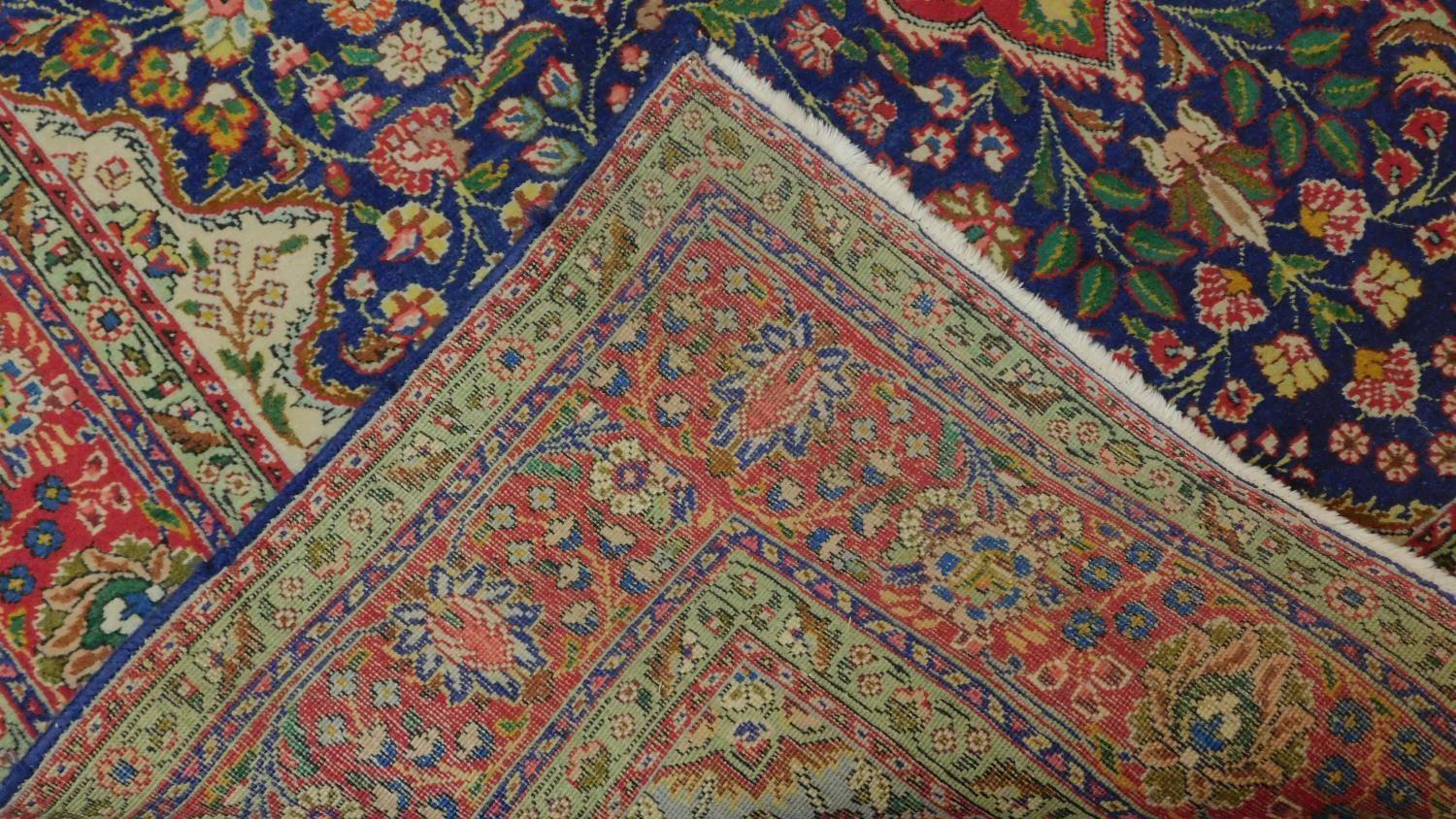 A Tabriz rug with central medallion and repeating floral motifs set on a predominantely rouge and - Image 3 of 4