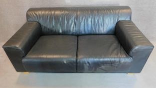 An Italian black leather sofa on solid block feet. 73x177x97cm (bought from Heal's, pair to the