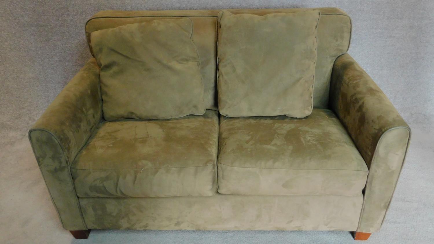 A 2 seater sofa in sage faux suede upholstery. 88x145x93cm