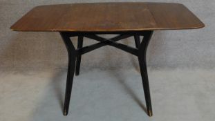 A vintage 1970's teak drop flap dining table on ebonised splay supports. 75x138x81cm