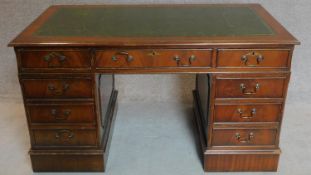 A Georgian style mahogany three section pedestal desk with tooled green leather inset top.