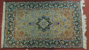 A silk Isfahan woollen rug with central pendant medallion surrounded by floral spandrels and a