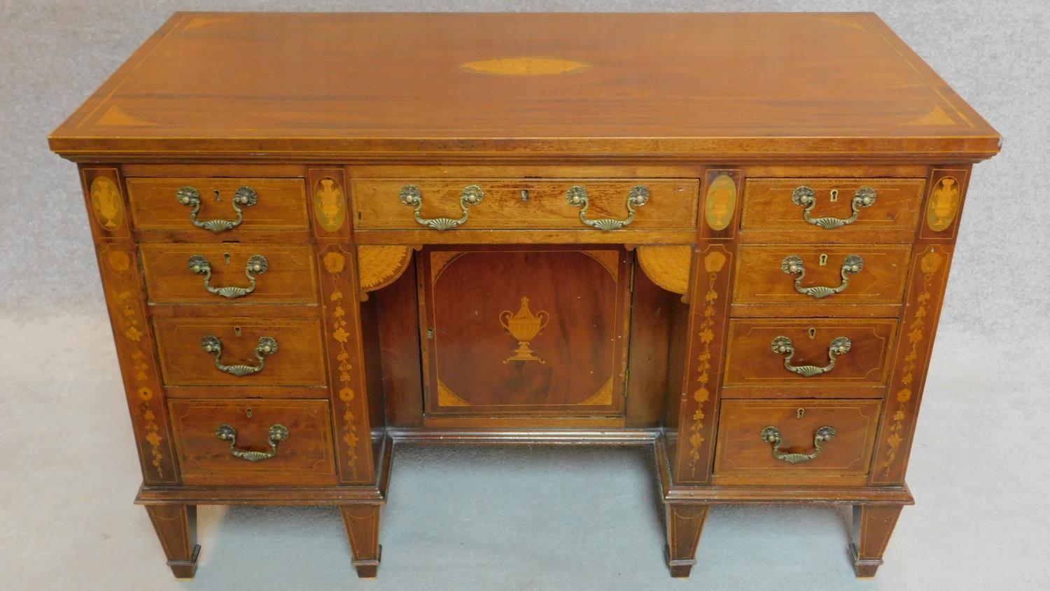 An Edwardian mahogany and satinwood inlaid kneehole desk with allover conch shell, swag and urn