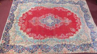 A large Persian Tabriz carpet, central double pendant medallion on a rouge field within floral