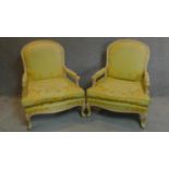 A pair of French style fauteuil with distressed painted frames in lemon floral upholstery. H.102cm