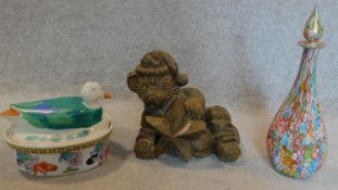 A coloured glass decanter, an animal carving and a lidded tureen.