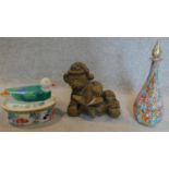 A coloured glass decanter, an animal carving and a lidded tureen.