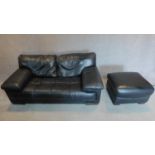 A black leather 2 seater sofa with buttoned seat and matching footstool. 75x179x98cm (sofa)