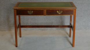 A Sheraton style mahogany and inlaid two drawer writing table on reeded square section stretchered
