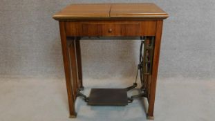 A vintage Frister and Rossman sewing machine in a fitted walnut side table. 80x70x50cm