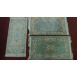 Three Chinese style floral rugs all set on a pastel field with central floral medallion within