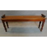 A late Victorian walnut window seat with turned supports. H.50 W.119 D.27cm