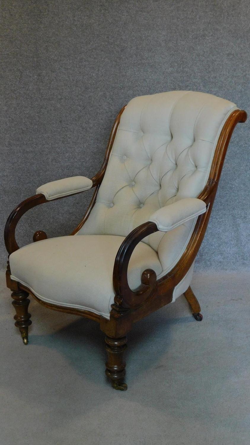 A Victorian mahogany framed buttoned back upholstered easy chair on turned tapering supports. H.91cm