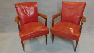 A pair of mid century teak red leather upholstered desk chairs. H.85cm
