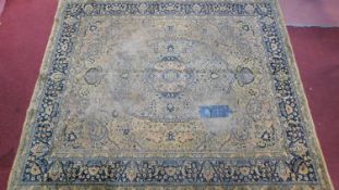 A Persian carpet with central foliate medallion on a ivory ground with palmette and petal motifs