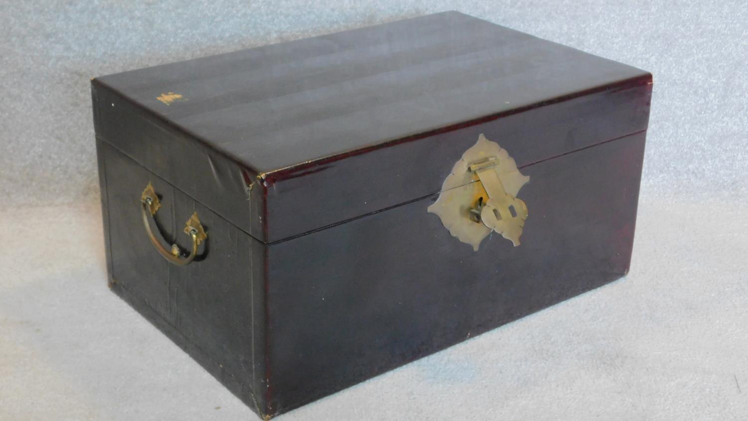 A Chinese black lacquered lidded box with brass lock and carrying handles. 31x63x42cm - Image 5 of 5