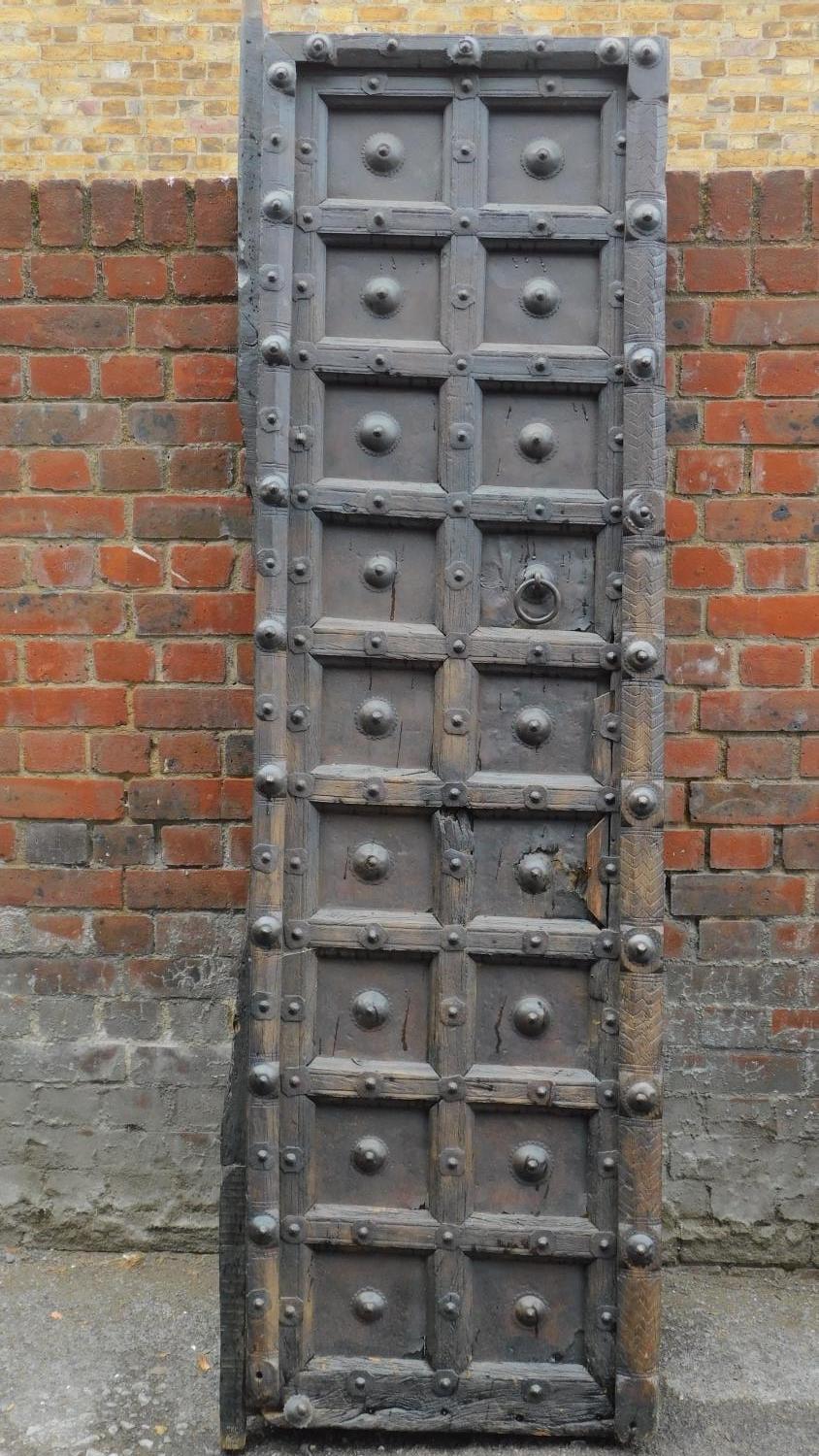 An Antique carved, panelled and studded door from the Kafiristan region of Afghanistan. 217x58cm