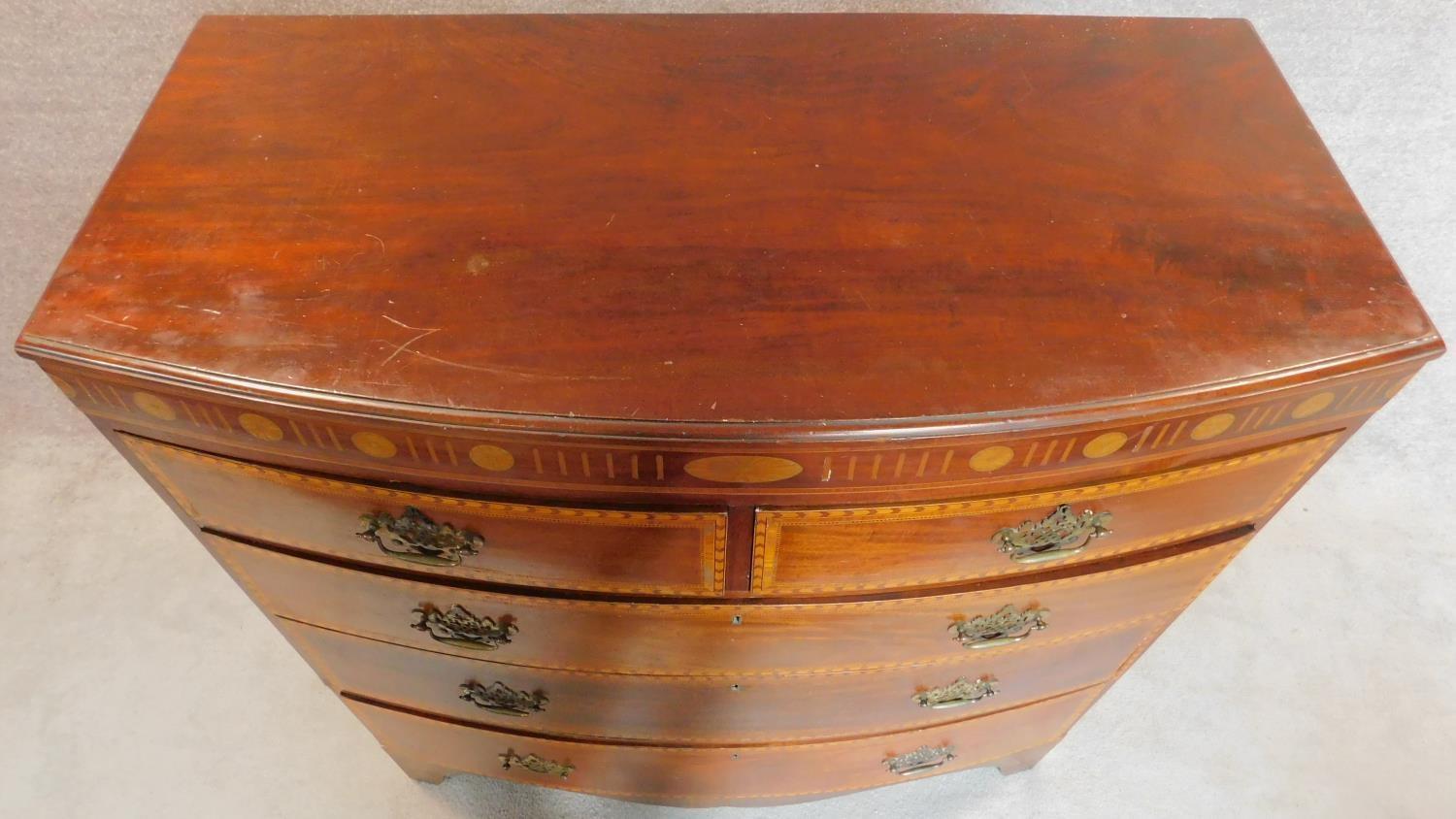 A Georgian mahogany and satinwood inlaid bowfront chest of two short over three long drawers. H. - Image 6 of 7