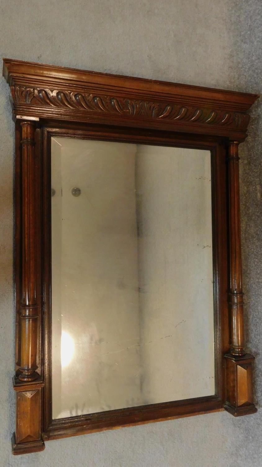A late 19th century Continental carved walnut overmantel mirror fitted bevelled plate. 114x89cm