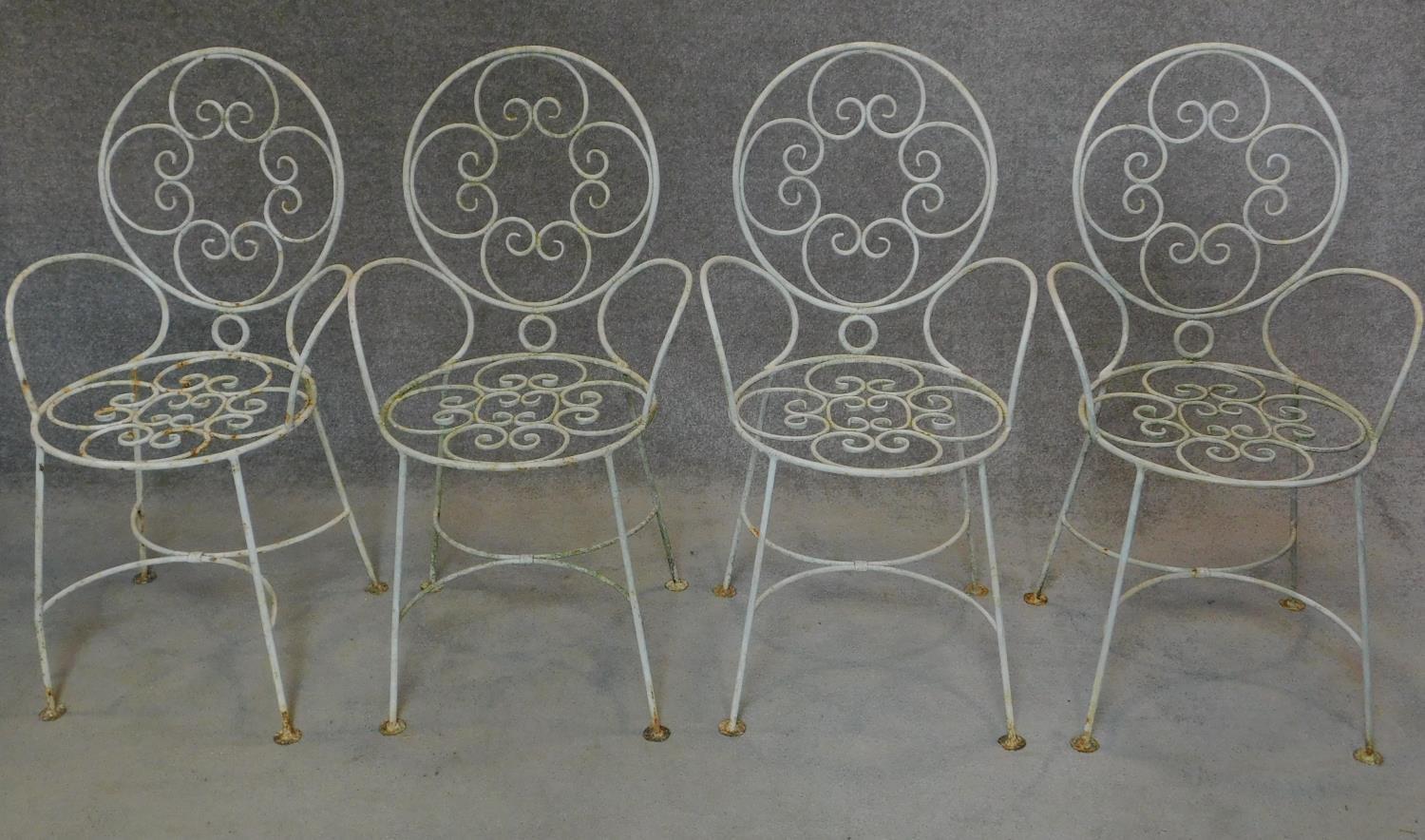 A set of four wrought iron and painted garden chairs. H.87cm